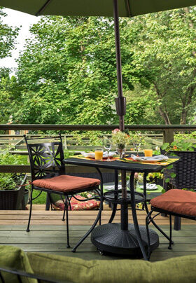 Table on deck overlooking the green back yard