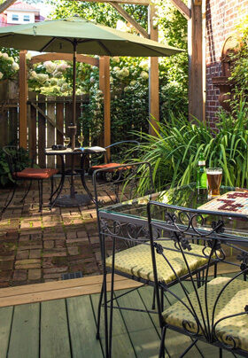 Courtyard with plants, metal tables and chairs and umbrella