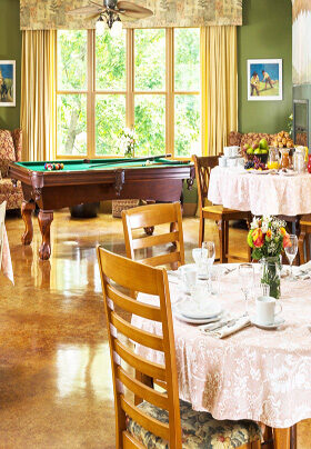 Room with dining tables and pool table.