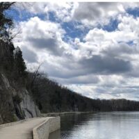 sky with cloads and a walking wooden ramp and water with reflection of the sky