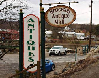 Exterior view during winter time of a wooden sign which says “Bruceton Antique Mall”