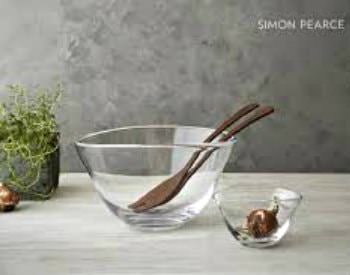 Two small glass bowls sitting on a grey countertop, wooden salad spoons in one bowl.