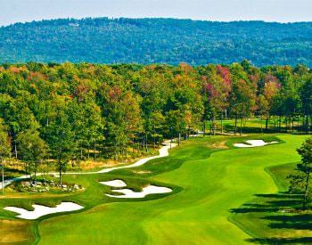 An aerial view of Wisp Lodestone golf course, an extremely vibrant green course surrounded by autumn trees